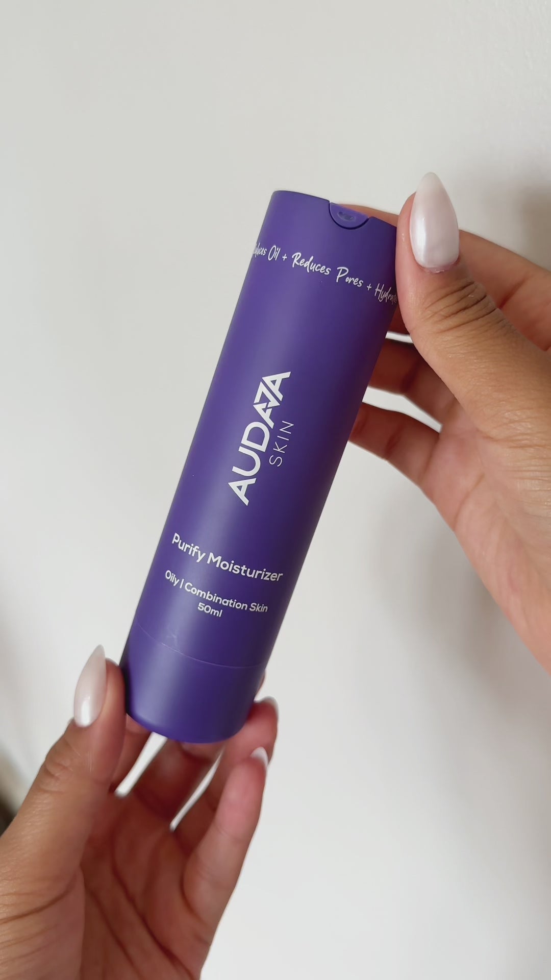 Person with glowing skin applying Purify Moisturizer on the face